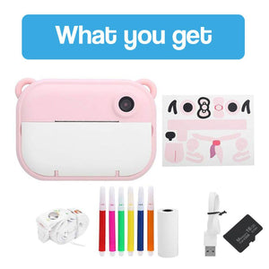 Pink kid instant print camera with markers, USB cable, thermal paper roll, memory card, and decorative stickers for creative photography gift.