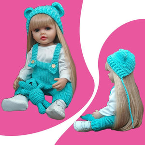 Real-feel baby doll with blonde hair in blue knitted outfit and bear hat holding matching teddy bear