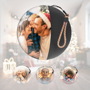 Video Memory Christmas tree ornament with personalized 3D holographic photo display sphere and wrist strap against festive background